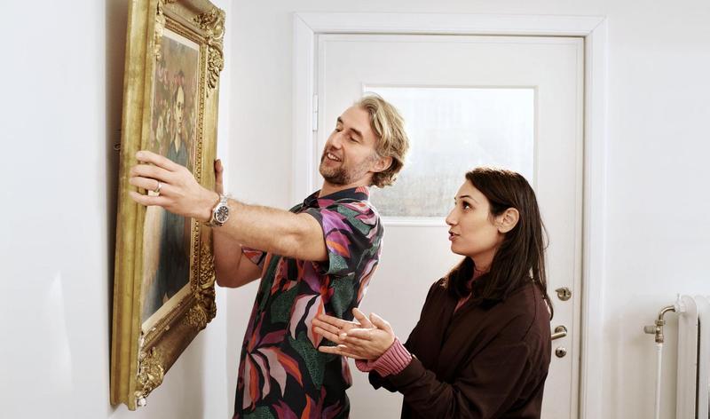 Couple hanging a painting on the wall